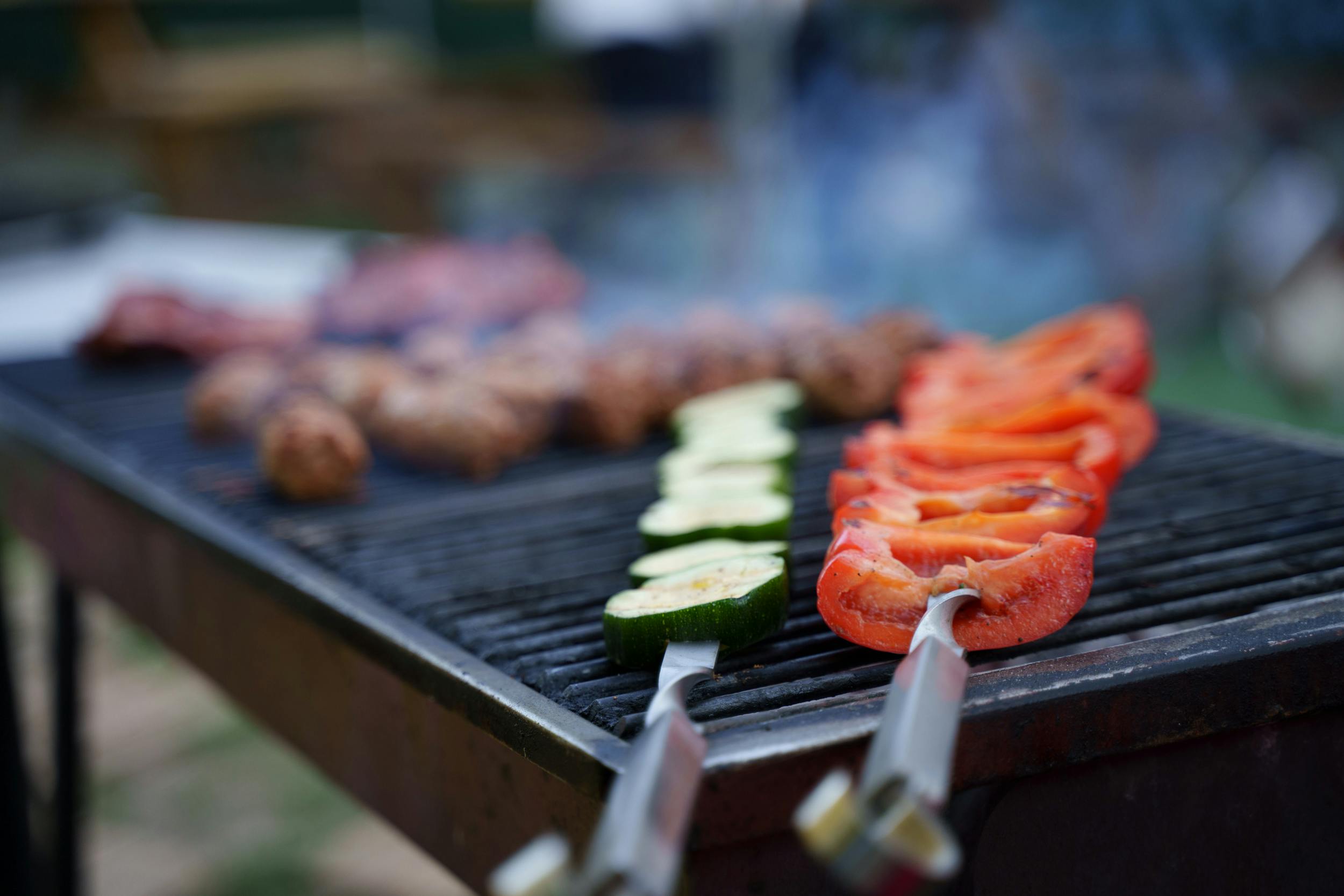 pexels-photo-18824016-18824016 Close-up of various meats and vegetables grilling on a BBQ, perfect for summer outdoor gatherings.